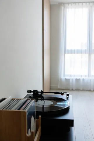 A modern vinyl turntable positioned neatly in an aesthetically minimalist living room.