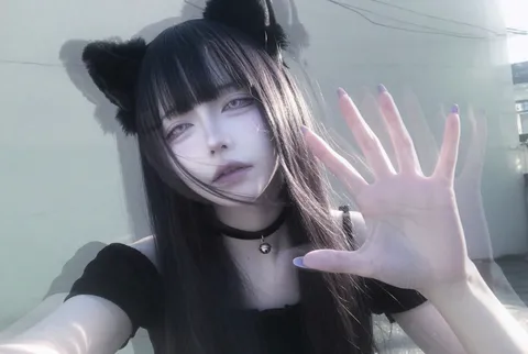Grainy casual selfie of a catgirl with pale skin, dark hair, and a black choker.