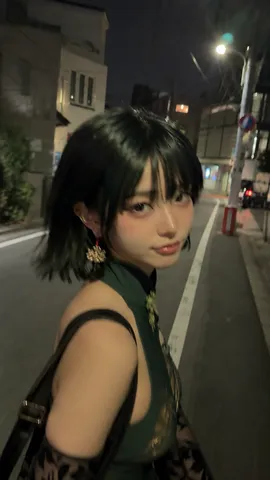 A casual motion-blurred selfie of a person walking down a city street at night under warm streetlights.