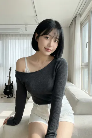 Portrait of a woman with a black bob and charcoal knitwear smiling softly in a modern home.