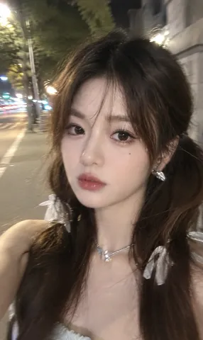 Casual motion-blurred smartphone street selfie illuminated by streetlights at night.