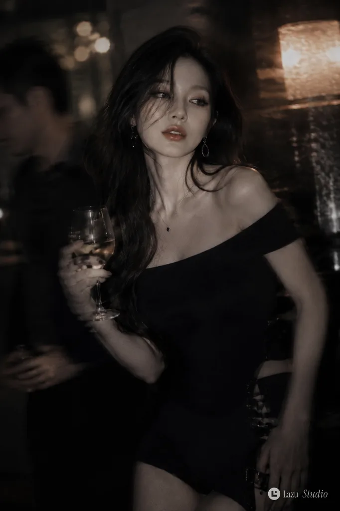 Korean idol holding a cocktail drink in a softly lit, moody night bar.
