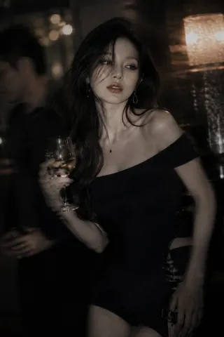 Korean idol holding a cocktail drink in a softly lit, moody night bar.
