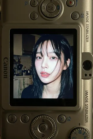 LCD screen of a compact digital camera showing a direct flash portrait of a woman.