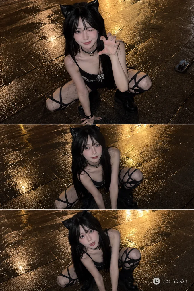 A woman with cat ears and straight dark hair crouching on wet city pavement at night, looking up at the camera.
