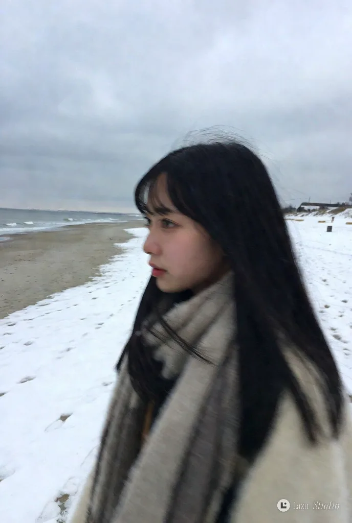 Side profile snapshot of a young Japanese woman in a coat walking along a quiet snowy beach in winter.