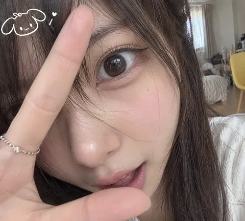 Extreme close-up selfie of a woman with one large eye, cheek, and hand framing her face.