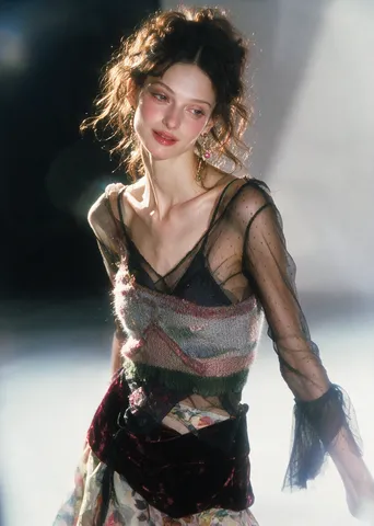 Slender woman in eclectic textured garments shot in a dreamy, retro DV camcorder style.