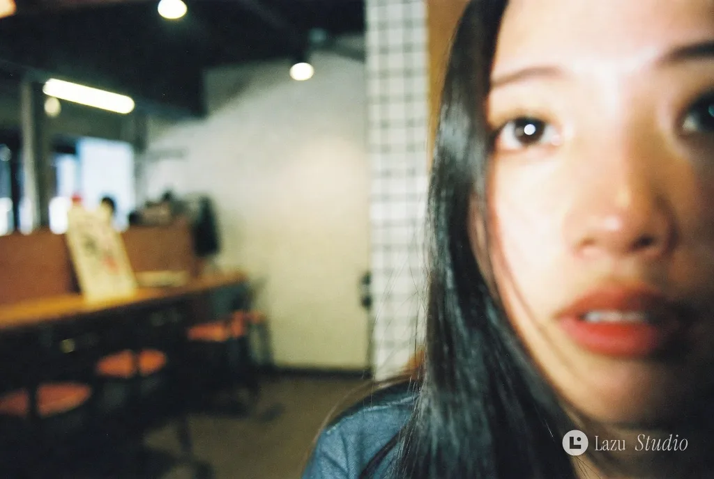 Candid photo of a young woman at an izakaya table.